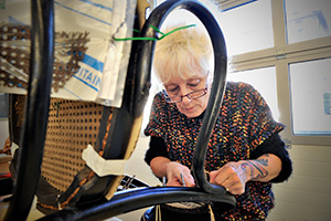 Ouvrière chevronnée de l'atelier de cannage
